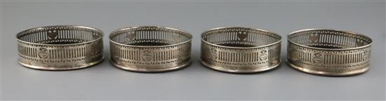 A set of four George V pierced silver wine coasters by Harry Freeman, 12.1cm.